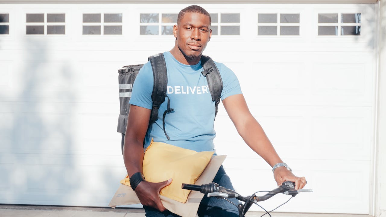 A Delivery Person Holding Parcels Riding a Bike